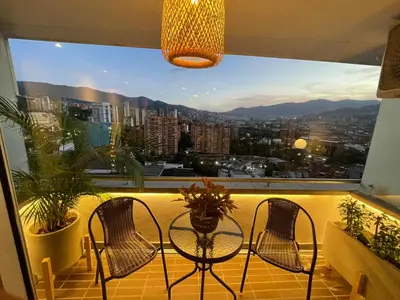 a balcony with two chairs and a table in front of a window at Premium Studio near Oviedo Mall, El Poblado- Balcony, AC & Fast WiFi in Medellín