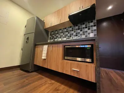 a kitchen with a microwave and a refrigerator at Premium Studio near Oviedo Mall, El Poblado- Balcony, AC & Fast WiFi in Medellín