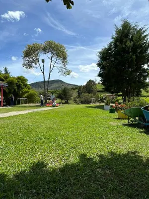 a park with a green field of grass and trees at Refugio del Atardecer in El Peñol