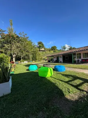 a group of green and blue tents on the grass at Refugio del Atardecer in El Peñol