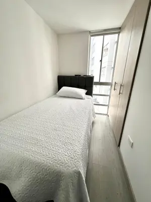 a bedroom with a white bed and a window at Espectacular apartamento in Manizales