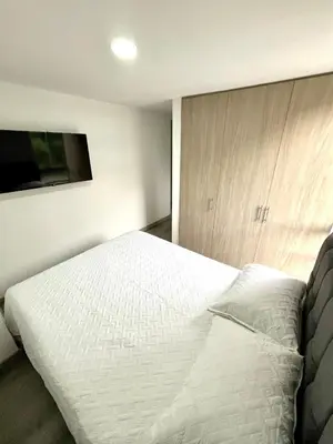 a bedroom with a white bed and a tv at Espectacular apartamento in Manizales