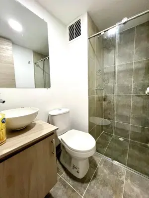 a bathroom with a toilet and a glass shower at Espectacular apartamento in Manizales