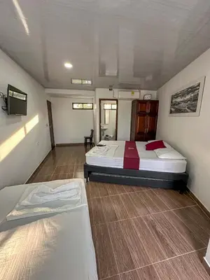 a bedroom with two beds and a tv in it at HOTEL COLONIAL santorini colombiano in Doradal