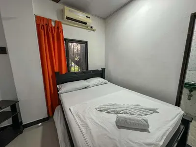 a bedroom with a bed with an orange curtain at HOTEL COLONIAL santorini colombiano in Doradal