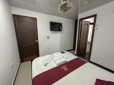 a bedroom with a bed and a mirror and a door at HOTEL COLONIAL santorini colombiano in Doradal