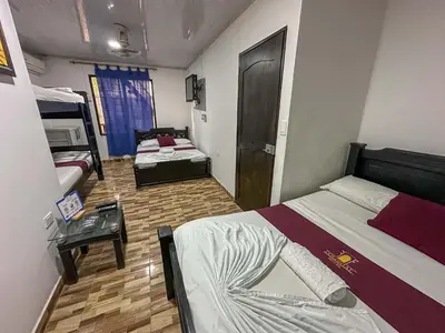 a small room with two beds and a table at HOTEL COLONIAL santorini colombiano in Doradal