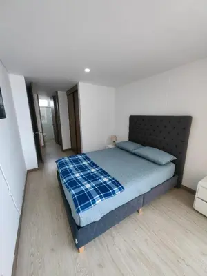 a bedroom with a bed with a blue blanket on it at Modern and Cozy Las Camelias in Manizales