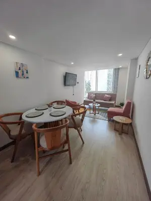 a living room with a table and chairs and a couch at Modern and Cozy Las Camelias in Manizales