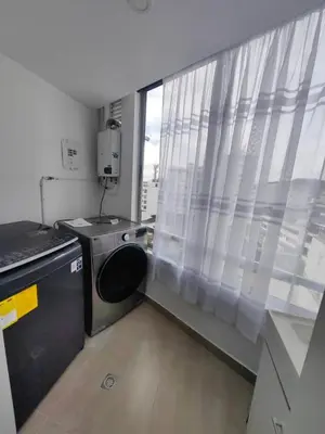 a laundry room with a washing machine and a window at Modern and Cozy Las Camelias in Manizales