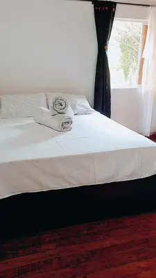 a large bed with white sheets and a window at Hotel Pekin in San Carlos