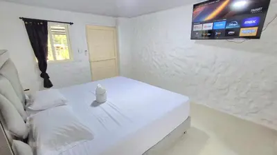 a white room with a white bed and a television at Hotel Pekin in San Carlos