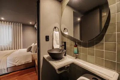 a bathroom with a sink and a bed and a mirror at 10th Street Three-Bedroom Jacuzzi & Billiard 201 in Medellín
