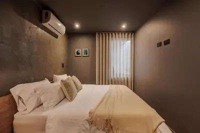 a bedroom with a large bed with white sheets and pillows at 10th Street Three-Bedroom Jacuzzi & Billiard 201 in Medellín