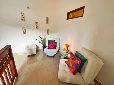 a living room with two chairs and a couch at Blomst Casa Hostal in Jericó