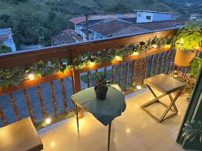 a balcony with a table and chairs and lights at Blomst Casa Hostal in Jericó