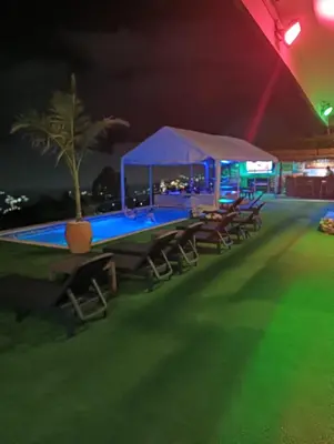 a group of tables and chairs next to a pool at night at VIVE PARADISE - UNICA HOSTERIA TERMAL Only Adult a solo 15 minutos de la ciudad in Medellín