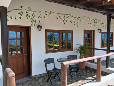 a house with a porch with chairs and a table at VIVE PARADISE - UNICA HOSTERIA TERMAL Only Adult a solo 15 minutos de la ciudad in Medellín