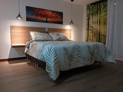 a bedroom with a bed with a wooden headboard at VIVE PARADISE - UNICA HOSTERIA TERMAL Only Adult a solo 15 minutos de la ciudad in Medellín