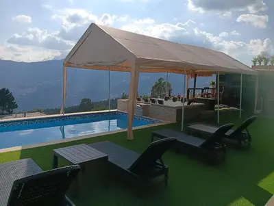 a pavilion with a table and chairs next to a pool at VIVE PARADISE - UNICA HOSTERIA TERMAL Only Adult a solo 15 minutos de la ciudad in Medellín