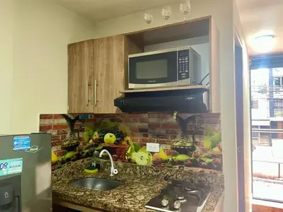 a kitchen with a counter with a microwave and a sink at Estudio renovado Belén, ubicación e iluminación in Medellín