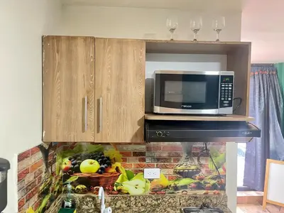 a microwave sitting on top of a kitchen counter at Estudio renovado Belén, ubicación e iluminación in Medellín