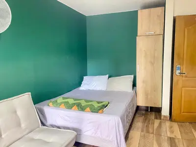 a small bedroom with a bed and a chair at Estudio renovado Belén, ubicación e iluminación in Medellín