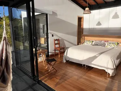a bedroom with a bed and a sliding glass door at Villa de lujo frente a la represa del Peñol in El Peñol