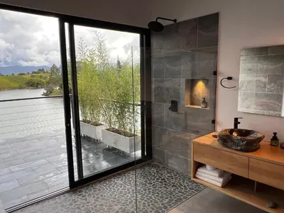 a bathroom with a shower and a sink and a window at Villa de lujo frente a la represa del Peñol in El Peñol