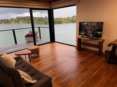 a living room with a large view of a lake at Villa de lujo frente a la represa del Peñol in El Peñol