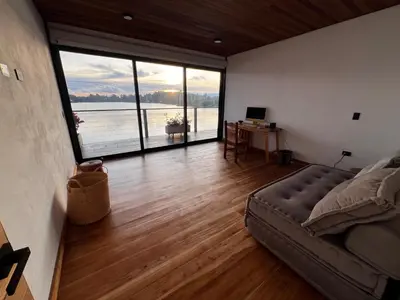 a living room with a couch and a large window at Villa de lujo frente a la represa del Peñol in El Peñol