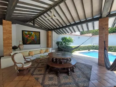 a living room with a table and a couch and a pool at Espectacular Casa en Cauca viejo con piscina, jacuzzi y turco in Jericó