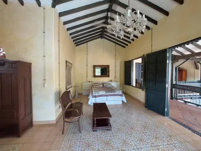 a large room with a bed and a chandelier at Espectacular Casa en Cauca viejo con piscina, jacuzzi y turco in Jericó