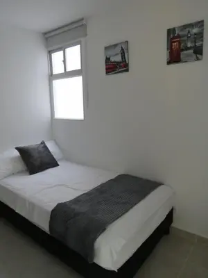 a white room with a bed with a window at Acogedor apto in Sabaneta