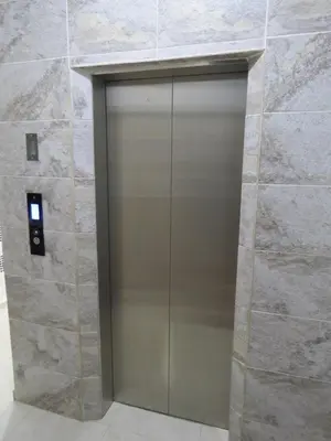 a metal elevator door in a stone wall at Acogedor apto in Sabaneta
