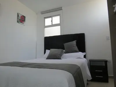 a bedroom with a large bed with a window at Acogedor apto in Sabaneta