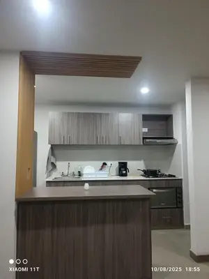 a kitchen with wooden cabinets and a counter top at Apartamento Moderno con piscina en Medellín Itagüí - sur in Estación El Salto