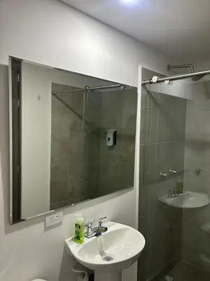 a bathroom with a sink and a shower with a mirror at Apartamento Moderno con piscina en Medellín Itagüí - sur in Estación El Salto
