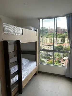 a bedroom with bunk beds with a large window at Apartamento Moderno con piscina en Medellín Itagüí - sur in Estación El Salto
