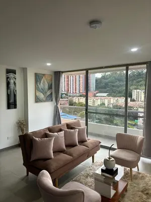 a living room with a couch and a large window at Apartamento Moderno con piscina en Medellín Itagüí - sur in Estación El Salto