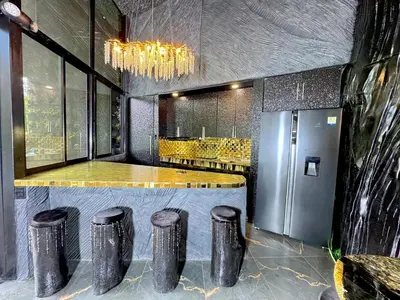 a kitchen with a bar with stools and a refrigerator at Luxury Villa Eleven Eleven in San Rafael