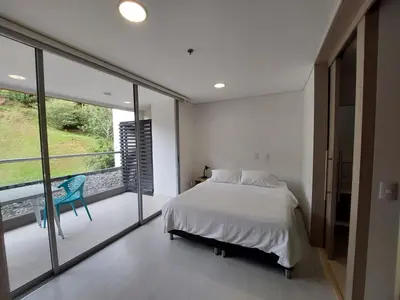 a bedroom with a bed and a balcony at Apartasuite en Rionegro, piscina, gimnasio y spa in Rionegro