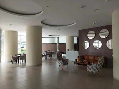 a lobby with chairs and tables and mirrors at Apartasuite en Rionegro, piscina, gimnasio y spa in Rionegro