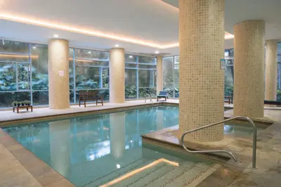 a large swimming pool in a building with windows at Apartasuite en Rionegro, piscina, gimnasio y spa in Rionegro