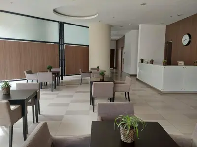 a waiting area in a hospital with tables and chairs at Apartasuite en Rionegro, piscina, gimnasio y spa in Rionegro