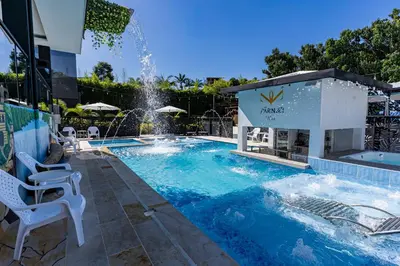 a swimming pool with a fountain in the middle at Hotel y Cabañas Parinzzi in Guatapé