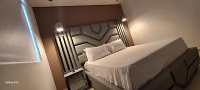 a small bedroom with a bed with white sheets at Hotel y Cabañas Parinzzi in Guatapé