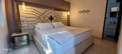 a bedroom with a large white bed in a room at Hotel y Cabañas Parinzzi in Guatapé