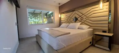 a bedroom with a white bed with a window at Hotel y Cabañas Parinzzi in Guatapé