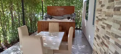 a table and chairs on a patio with trees at Hotel y Cabañas Parinzzi in Guatapé